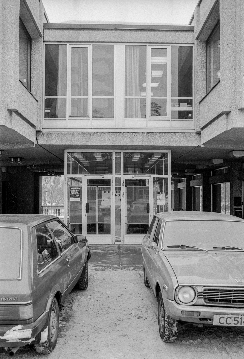 Sentrumsbygget på Kolbotn. Innganspartiet med parkerte biler foran. en mann går forbi. Rulletrappene nedenfra og ovenfra.