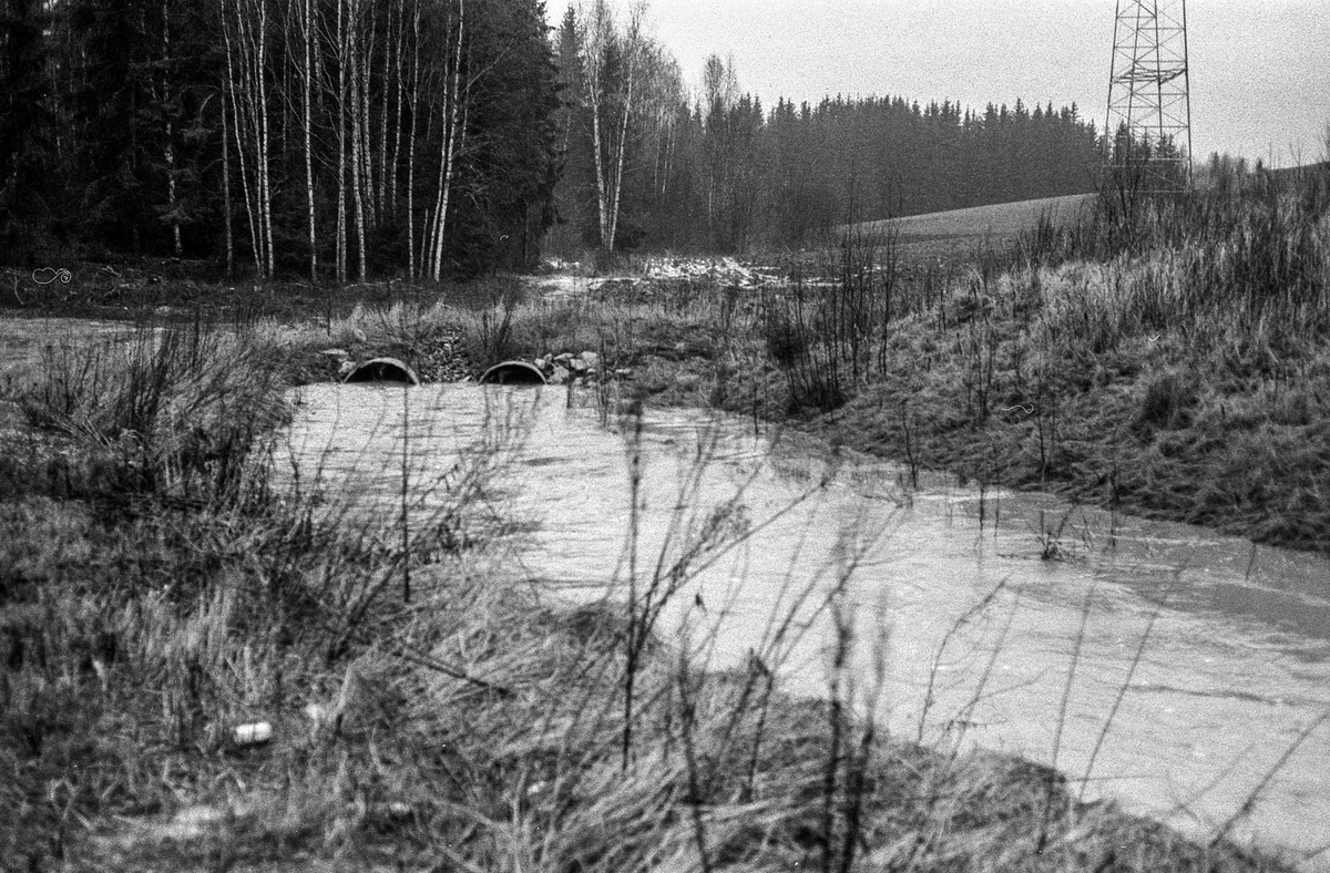 Flom i Follo. Dame øser vann i kjelleren med plastbøtte. Flom over veier og jorder mellom Horgenkrysset i Ås og Frogn. Biler kjører i flomvannet.