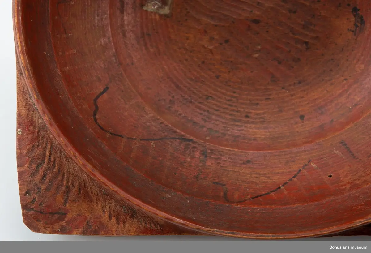 Svarvad låg skål med fyra utskjutande "snibbar" nedanför den runda mynningen. De sitter placerade i en fyrkant.
Målad i rostrött på både ut- och insida. På "snibbarna" samt inuti löper det en svart vågig dekorlinje. Inuti finns det även spår av  guldränder.
Färgen är sliten.
Skadedjursangrepp.
I botten har det suttit en äldre 'frimärksetikett'. Under botten  är "NBS" inskuret.

Se Knut Adrian Anderssons "Katalog I, A. yngre föremål" under Uddevalla museum/förening D 2A:1 i arkivet.

Förvärvad från Samuelsson, Svante Justivius; Gästgivare, Sörbo, Orust.

Litt; 
Hallset, G.: Svarvning i Ås härad, s. 25-32 och Svenningson, S.: Streckmålade toarpsaskar, s. 33-44, i Från Borås och de sju häraderna, Fässingen, 2001 - Årgång 47.
Kjellberg, Sven T, Ölets käril - Om bollar med handtag kallskålar och snibbskålar, Kulturen 1964, Lund 1964, s. 49-59.
Se bilagepärm: Kopia av tidningsartikel "Flitigt svarvande i Sjuhärad" av Gunilla Hallset i Borås Tidning lördagen den 19 maj 2001.

Ur handskrivna katalogen 1957-1958:
Snipaskål
L.22. Br. 20,5. Trä. Rödmålad. 4 hörn. Märkt: N.B.S. Föremålet helt. Hede. Bohusl.

Lappkatalog: 67