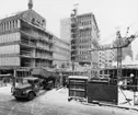 I förgrunden byggs huset Rådmansgatan 65, vari postverkets läkarcentral skall inrymmas. I fonden Postbankshusets centrumdel.