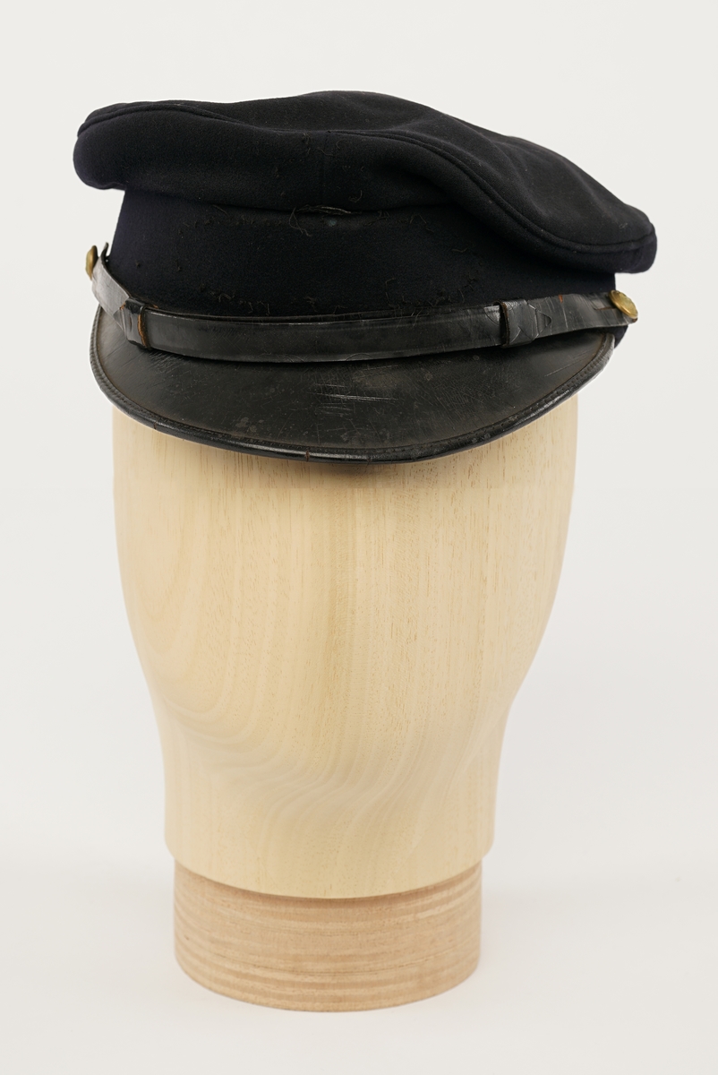 Mørkblå dame jakke enkelspent med fire riksløveknapper. Epauletter med merkurstav, krone, og to kvist eikblader (fire blader totalt) mellom to gullbånd. Tekstil marke på begge armer, krone over riksløve med hvit øks i rød skjold omgitt av eikeblader over TOLL/CUSTOMS. Hempe i nakke. Kypert stoff, blanding av polyester og ull. Jakke er foda med antatt syntetisk stoff, sort.
Hvit hatt med sort visir. Metall distinkjons skilt av krone over riksløve med søkvferget øks i rød skjold omgitt av eikeblader. Gullfletting over visir, og eikeblader på visir.
Lys blå dame skjorte med matchende distinktsjoner og tekstil merker på armene.