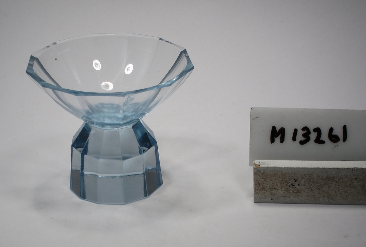 Likörskål.
Färg: Blåtonat, klarglas.
Mått: Ovan anges höjd och diameter. Fotdiameter: 37 mm.
Inskrivet i huvudkatalogen 1953.

Tillhör karaff M 13260.
Funktion: Likörglas/skål