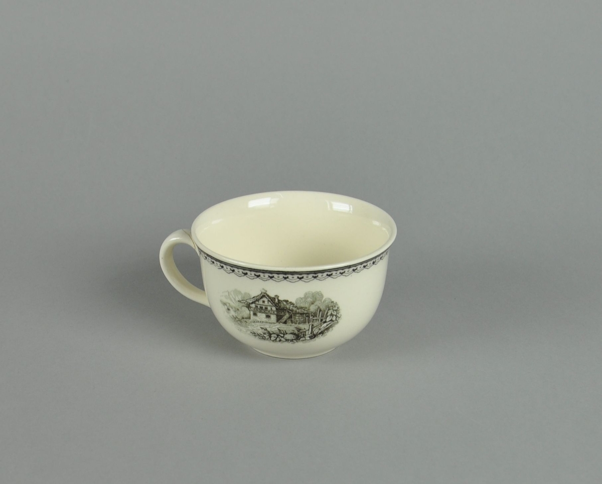 Kopp av glassert keramikk, med hank. Svart dekortrykk av klosterruiner og gård, samt en borde langs randen. Hanken har vært knekt av og limt på igjen.