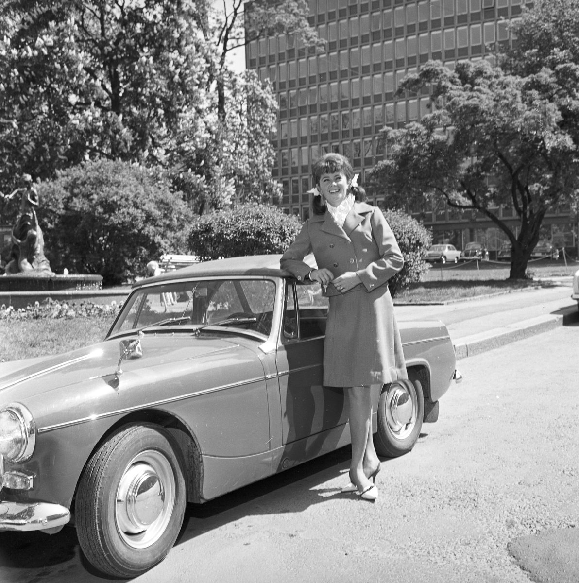 Wenche Myhre står ved en bil. Fotografert 10.06.1965
.