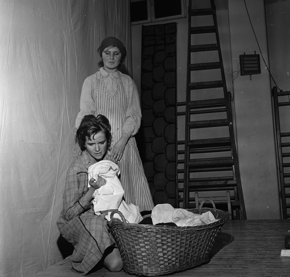 Fra oppsettingen av et skoleteater. To jenter sammen på scenen. Fotografert 10. januar 1963.