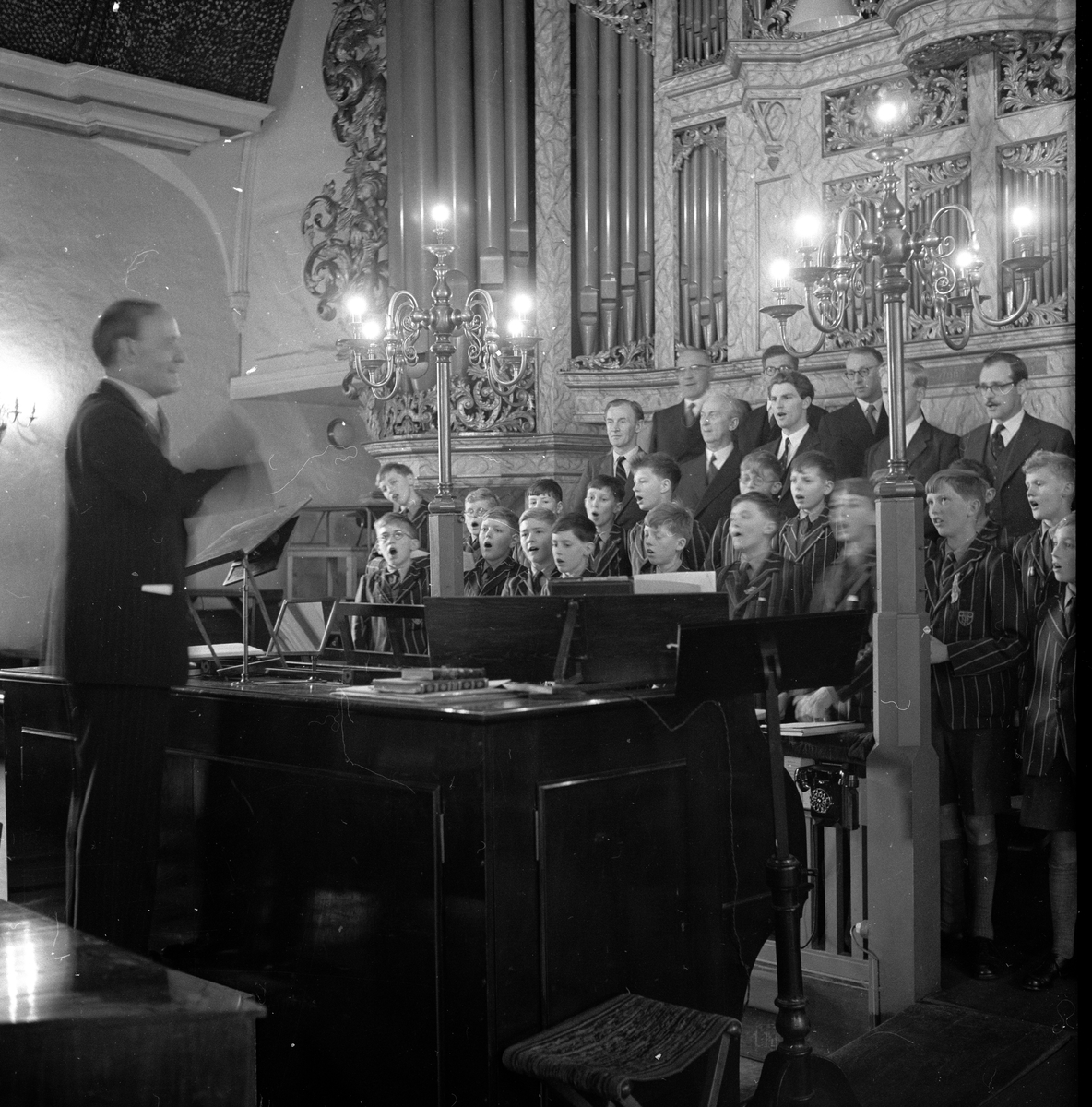 Westminster Abbey Choir synger i Oslo Domkirke med en dirgent ved piano. Fotografert 7. okteober 1958.
