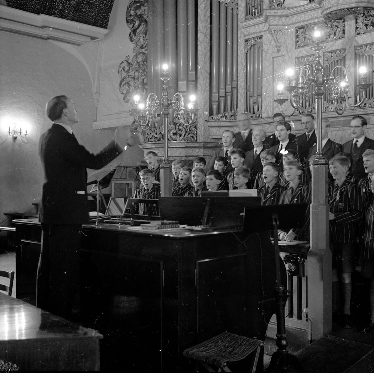 Westminster Abbey Choir synger i Oslo Domkirke med en dirgent ved piano. Fotografert 7. okteober 1958.