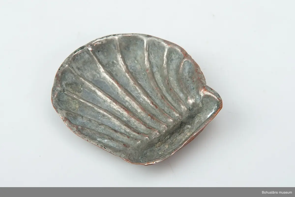 Ur handskrivna katalogen 1957-1958:
Liten kopparform
Mått c:a 8,5 x 7,9 cm. Tio "strålar" utgående från ett gemensamt horisontalt fäste. Föremålet relativt helt.

Lappkatalog: 59