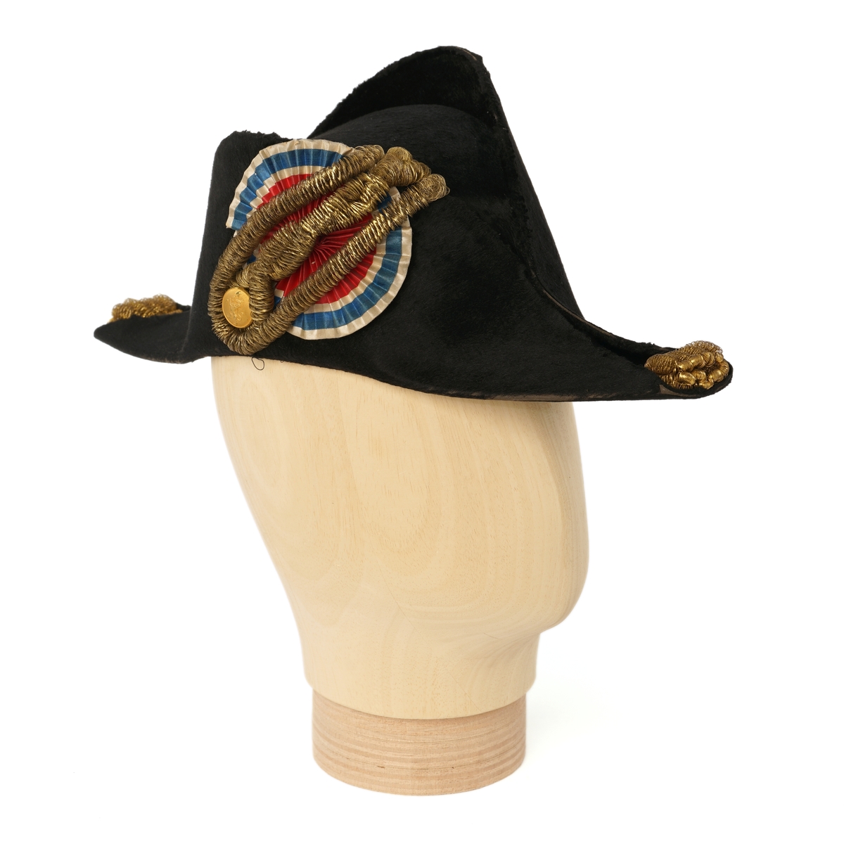 Snutehatt av sort, velurlignende stoff. Rød-hvit-blå kokarde, gulltresse med riksløveknapp. Gullpynt i hver snute. Brunn skinn til svetterem, blå silkefôr. To sort knapper (en mangler) i toppen av innsiden pull.
Metall hatteske til snutehatt.