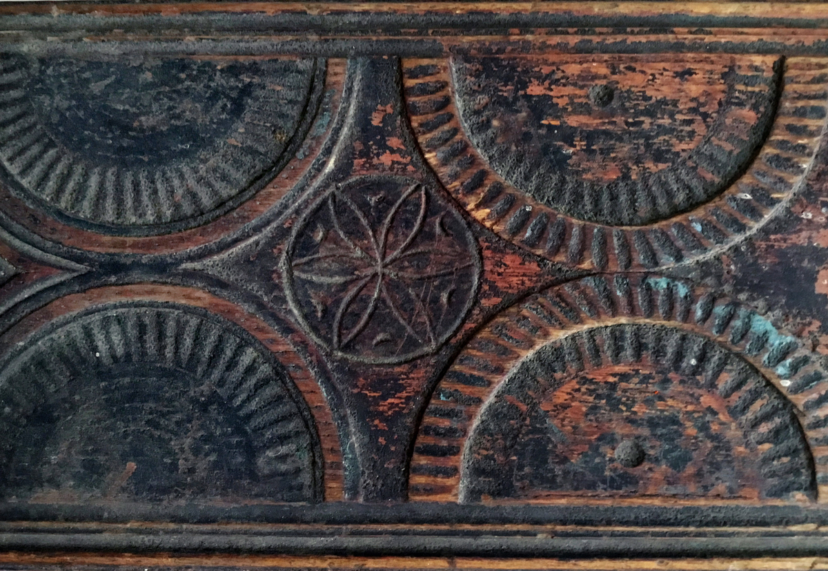 Mangletreet er malt rødt og sort. Karveskurd. Hestehåndtak, smal profil på sidene. Sikk sakk ornamentikk ved hestehåndtaket. Dekorert med sirkler og halvsirkler, og seksbladsroser i sirklene. Lærhempe i enden. Håndtaket festet med jernskruer.