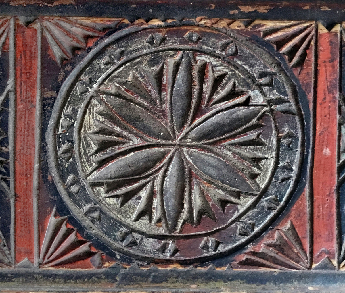 Mangletreet er malt rødt, sort og kvitt. Karveskurd. Hestehåndtak. Afrundet foran. Dekorert med store og små seksbladsroser.