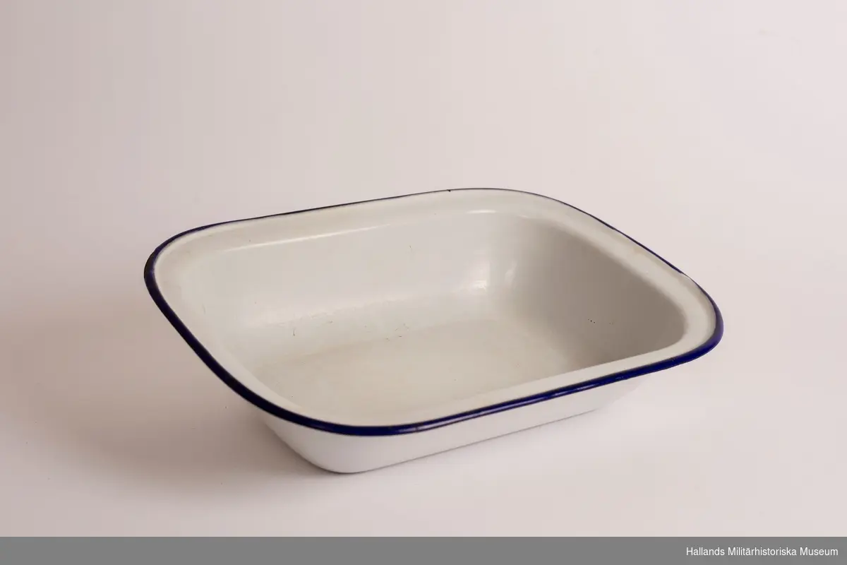Ett djupt fat. rektangulärt, vit och med blå kanter. Emaljerad metall. Fabriksmärkt på undersidan. 30 cm.