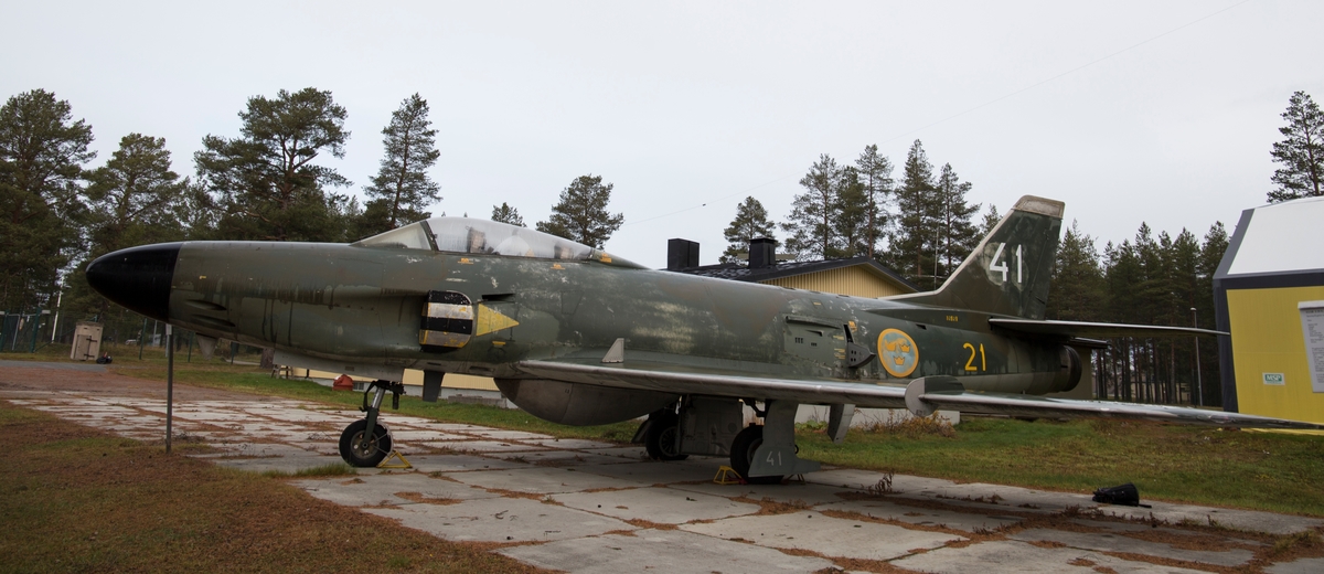 Jaktflygplan, J 32E
Saab 32 Lansen

Tvåsitsigt flygplan som är utrustad med  flygmotor Rolls Royce Avon (Svenska Flygmotor RM 6A). 
Märkning: På bakkroppen kronmärke och flottiljnummer 21; på fenan kodsiffra 41.