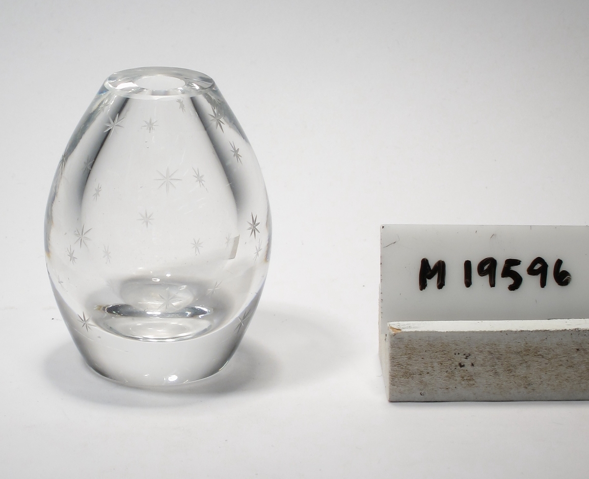 Litet blomglas.
Beskrivning: Äggformad. Graverad med stjärnor.
Färg: Ofärgat klarglas.
Mått: Ovan anges höjd samt maxdiameter.
Inskrivet i huvudkatalogen 1968.
Funktion: Litet blomglas