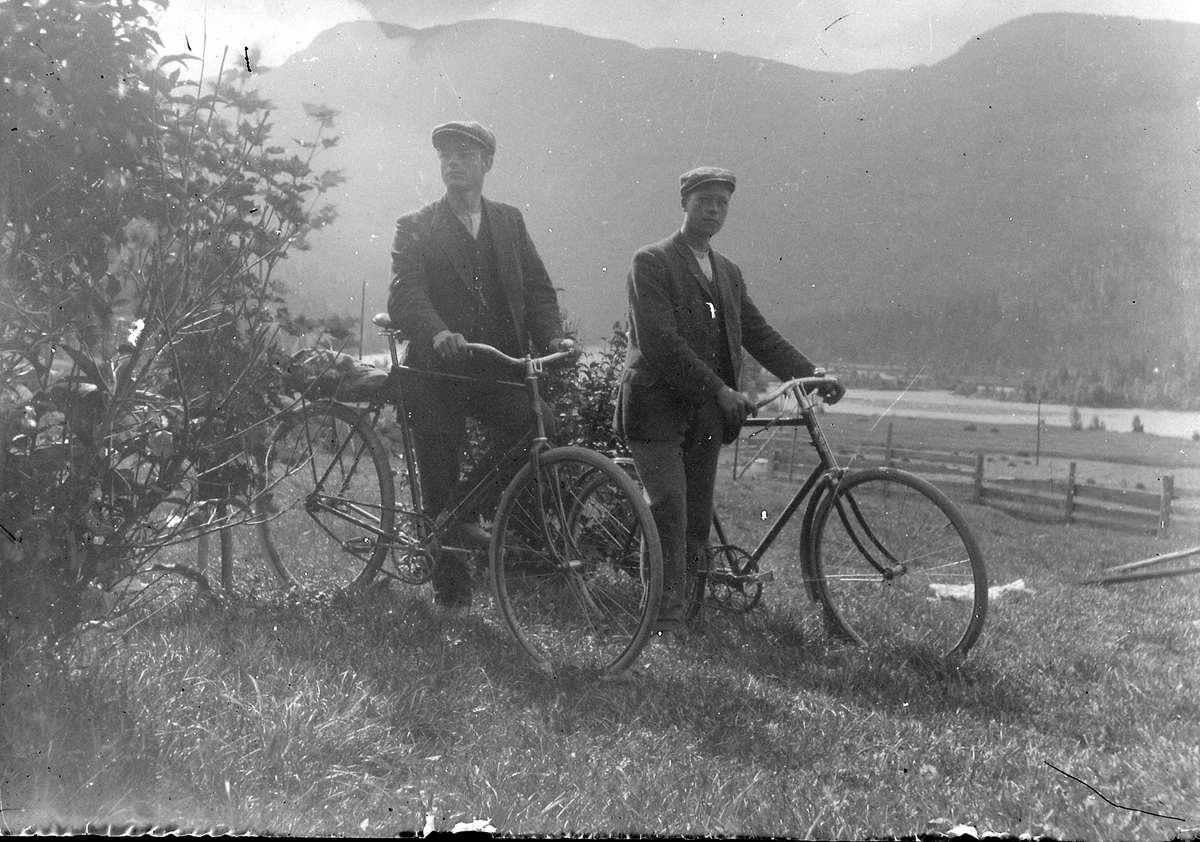 Fotoarkiv etter Aanund Edland. Utendørs portrett av Bjørgulf Kvomme t.v. og Sondre Bratland med sykkel.