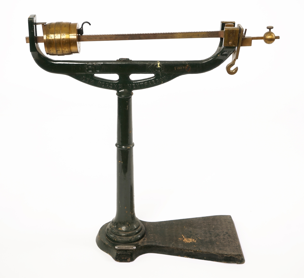 Balansevekt av metall bestående av fot,ben,vektarm og vektskål.