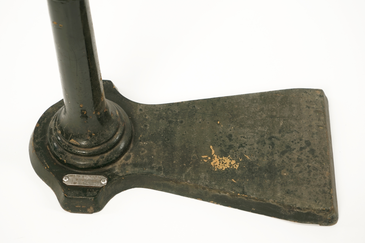 Balansevekt av metall bestående av fot,ben,vektarm og vektskål.