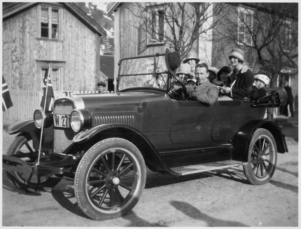 Gruppebilde med flere personer sittende i en Chrysler Roadster (1928 modell?).