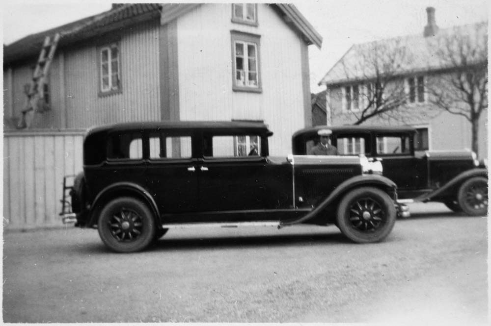 Person på drosjeholdeplassen ved fisketorget i Mosjøen mellom en Nash 1930 og en Chrysler 1930.