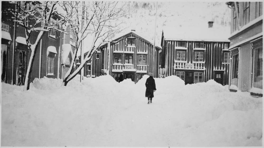 Vinterbilde. Sjøgata sett fra Peter Bechs gate, med en kvinne som går. Vikgården til høyre.