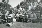 Kila sn, Sätra brunn.
275-årsjubileet 1975.
Orkester spelar för gästerna som sitter i trädgårdscaféet.
Instrument - bland annat cymbal, trummor och något blåsinstrument, ev.