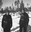 Flygförarna Björn Bjuggren och Hugo Beckhammar iklädda flygdräkt i Märkäjärvi vid Svenska frivilligkåren i Finland, F 19. I samband med medaljutdelning av det finländska Frihetskorset, vilka hänger på flygförarna.