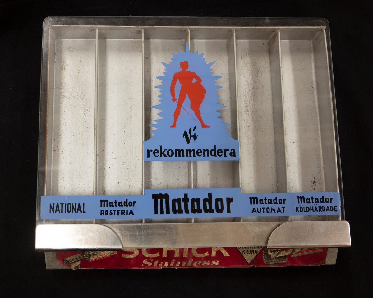 Ett ställ för rakblad. Sex olika fack för olika rakblad, för försäljning: National, Matador fostfria, Matador, Matador automat, Matador köldhärdade