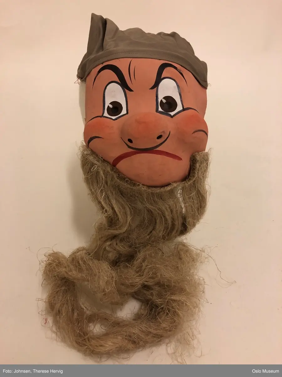 A: Snehvit
B: Sleepy, gul lue, skjegg
C: Sneezy, grønn lue, langt skjegg
D: Grumpy, beige lue, langt skjegg
E: Dopey, fiolett lue
F: Happy, rød lue, langt skjegg
G: Doc, gul lue, skjegg