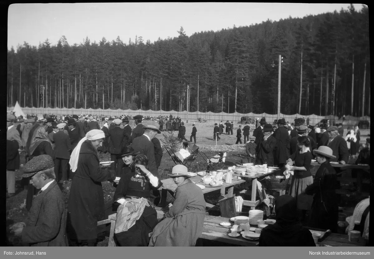 Fylkesutstillingen 1922. Folkemengde utendørs. Matservering ved benker.