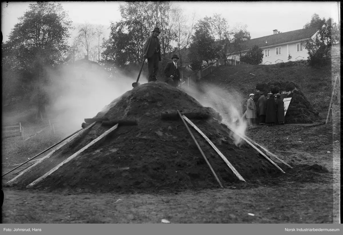 Fylkesutstillingen Kongsberg 1924. Mennesker stående på en kullmile.