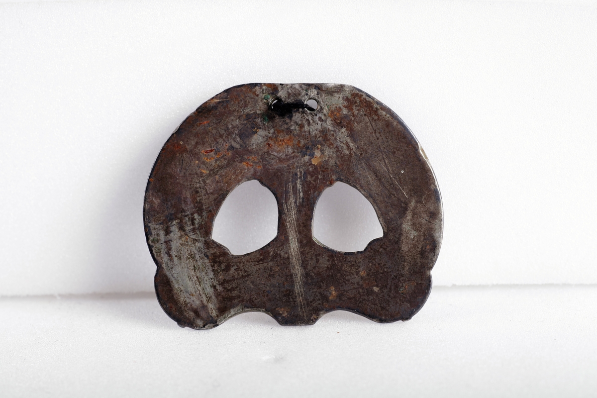 Sølvbeslag og en liten del av dens festeinnretning, forgylt med nielloinnlegg, som type R. 200 d fra eldre jernalder. Utsmykning til sverdslire. Funnet i en gravhaug på gården Mellom-Kvem.