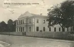 Ett år 1920 postgånget brevkort med vy mot en av flera tillfälliga militärförläggningar som uppstod i Linköping under 1910-talet. Skälet till att värnpliktiga fick förläggas inne staden var de segdragna turerna kring var de planerade anläggningarna för Första och Andra livgrenadjärregementena skulle placeras, vilket gav förseningar som följd. Det avbildade huset hade ursprungligen uppförts i början av 1880-talet som teater- och cirkusbyggnad i den så kallade Wernerska trädgården, som under 1800-talets senare hälft utgjort platsen för ett av stadens största nöjesetablissemang. Vid tiden för bilden var epoken av förströelser emellertid förbi och lokalen fanns tillgänglig för uthyrning.