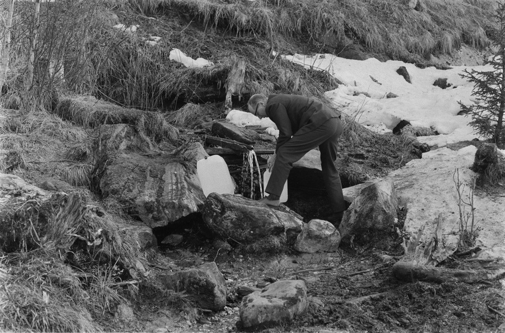 Vannhenting i Bjørnådalen, vannkilda sommeren 1969.
Mann som fyller vann på plastdunk.