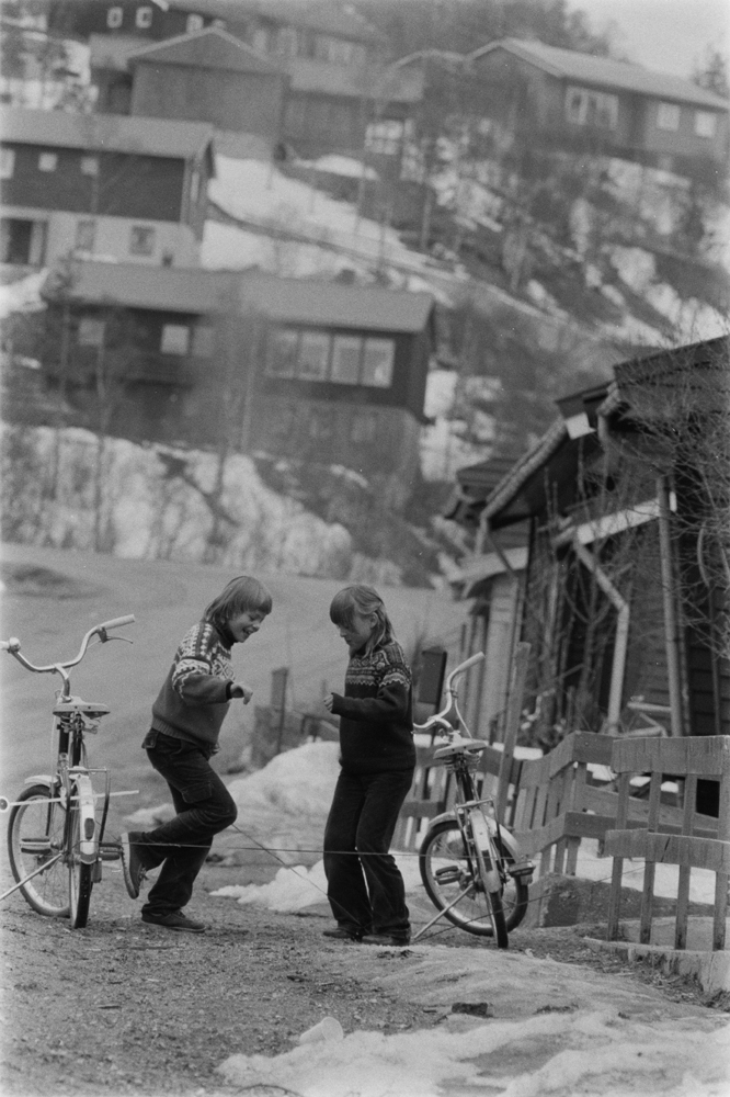 Barn som hopper strikk på  Hals. Vi ser en del av bebyggelsen rundt.
Foto:Ragnar (Til Bygg og bo)