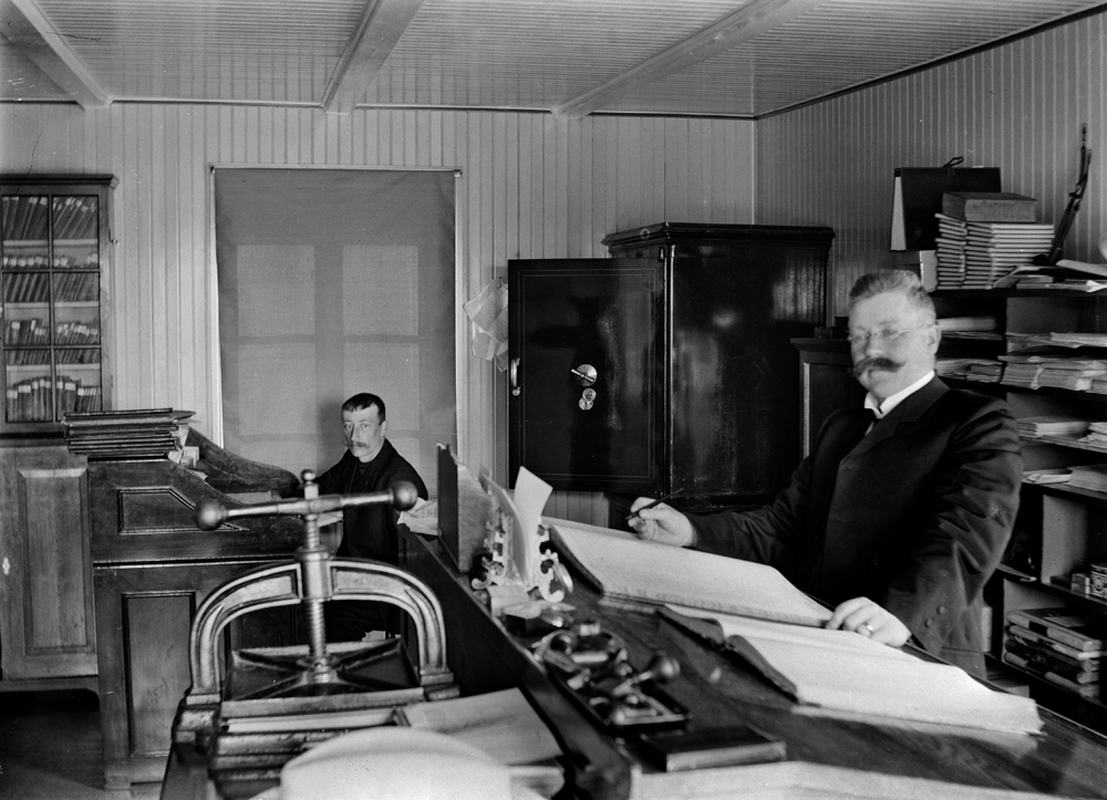 Herredskasser i Vefsn, P.A. Smith på sitt kontor i kommunehuset i Torolfs gate. I bakgrunnen kontorbetjent Martin Johansen.