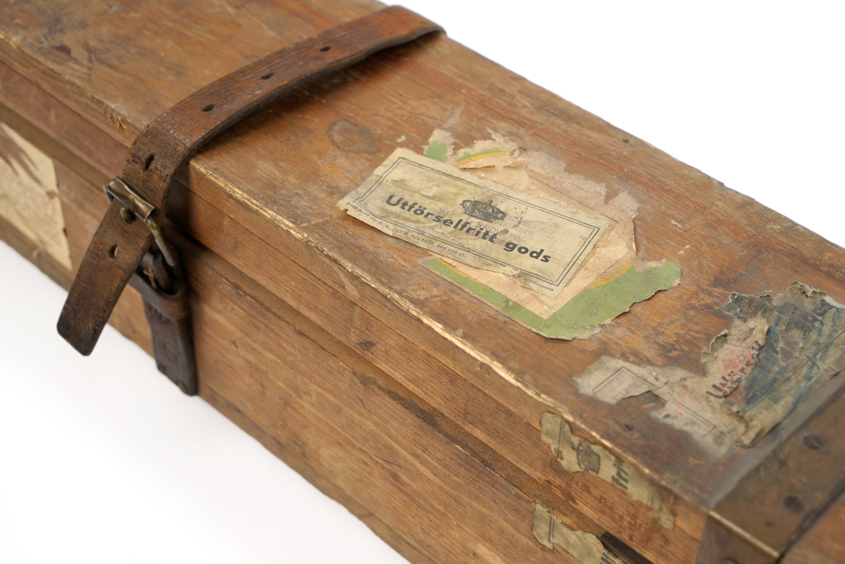 Trekasse med låsbart, hengslet lokk. Nøkkel mangler. Kassen er forsterket med metallbeslag. Lokket kan også låses med to påskrudde lærreimer med spenner. Nøkkelhullet er forsterket med metallbeslag.