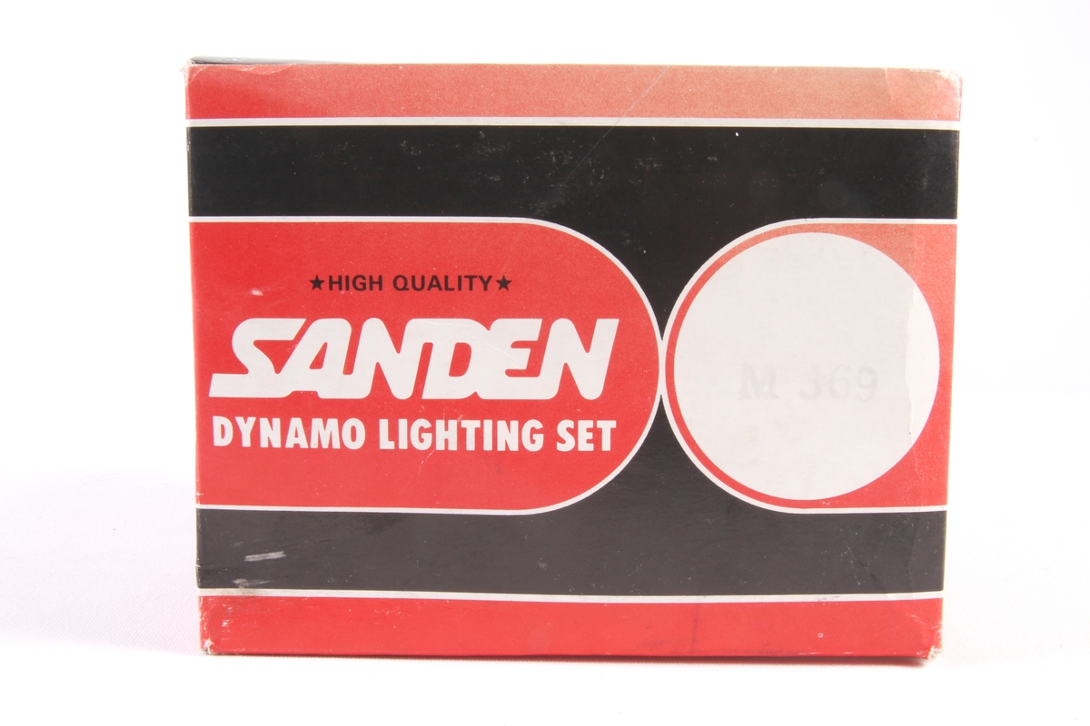 Sett med sykkellykt og dynamo i original emballasje. Sykkellykt har en rektangulær avrundet form og to lyspærer innvendig.