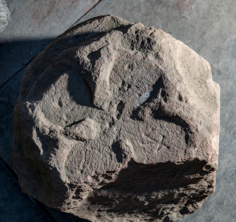 Redish sandstone with a carved four blade rose.