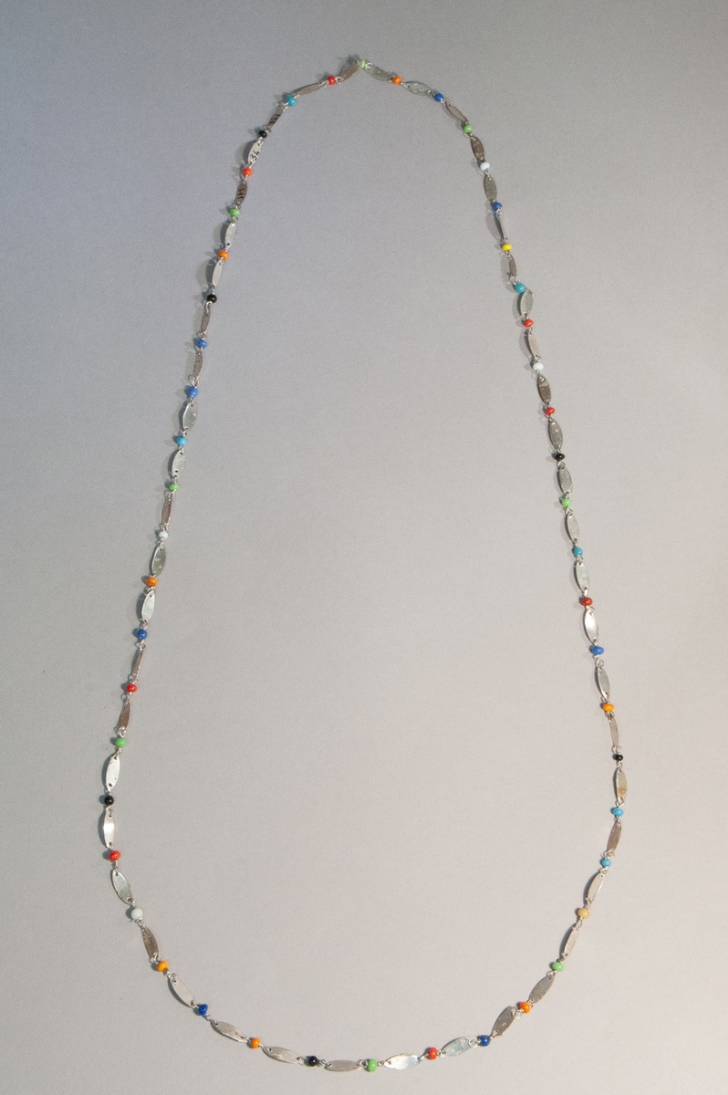 Halsband med ovala metallplattor och glaspärlor i svart, blått, rött, orange, gul, grönt och vitt.