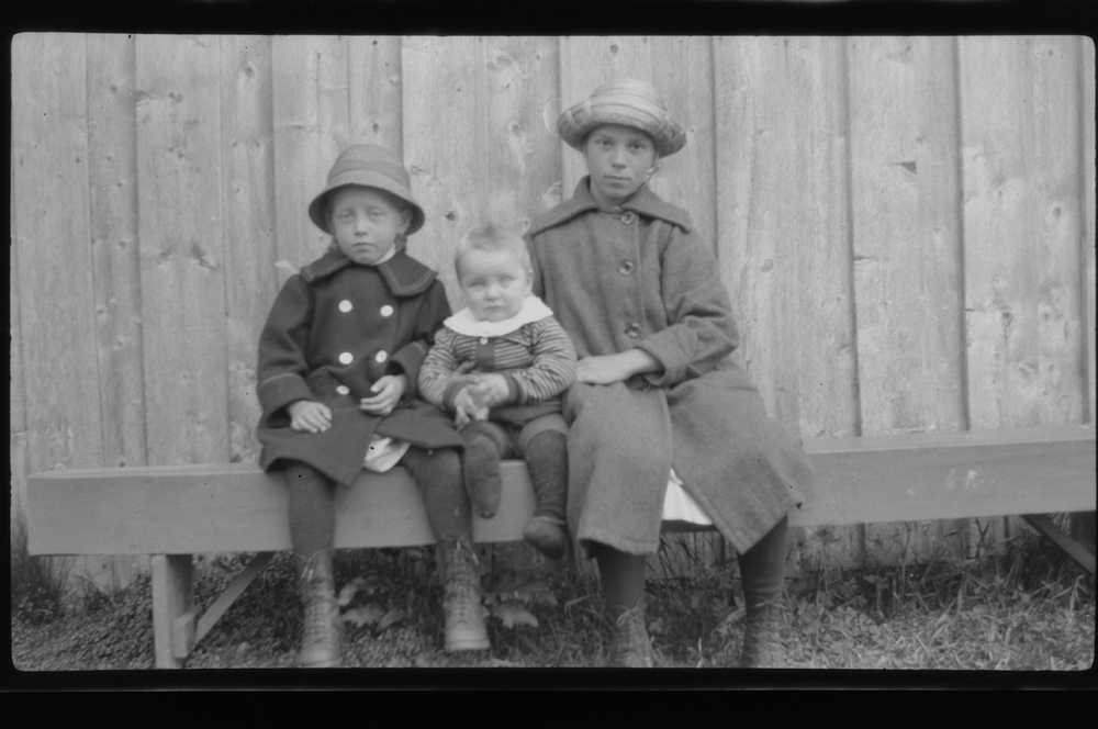 Tre barn på benk.
Fra v. Nelly Øyen (g. Fjellseth), Odd Bakke og Petra Reinfjell.