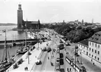 Stockholms stadshus. Spårvagnstrafik vid Tegelbacken, och del av Riddaholmsbron på Statens Järnvägars SJ:s bandel mellan Stockholm C och Riddarholmen.