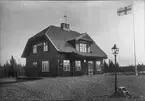 Eneryda järnvägsstation, uppförd 1913.  Notera att flaggan ser inverterad ut, detta är en bieffekt av den typ av film, ortokromatisk film, som användes vid den här tiden.