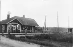 Kinnemalma stationshus. På moderna kartor kan orten heta Malma och själva fastigheten är Kinne-Malma. Österplana kyrka i horisonten.