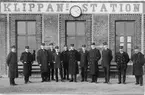 Gruppfoto med stationen i bakgrunden