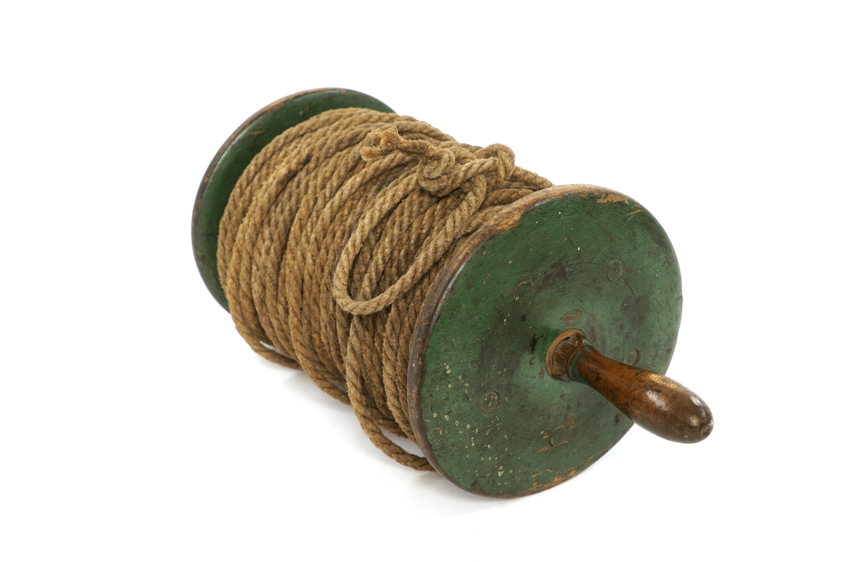 En snelle av tre med en gjennomgående treaksel med trehåndtak i hver ende. Det en trehåndtaket er delvis borte. I tillegg er det fem trelister som er festet mellom snellevangene  og som et antall meter med tau er rullet rundt.