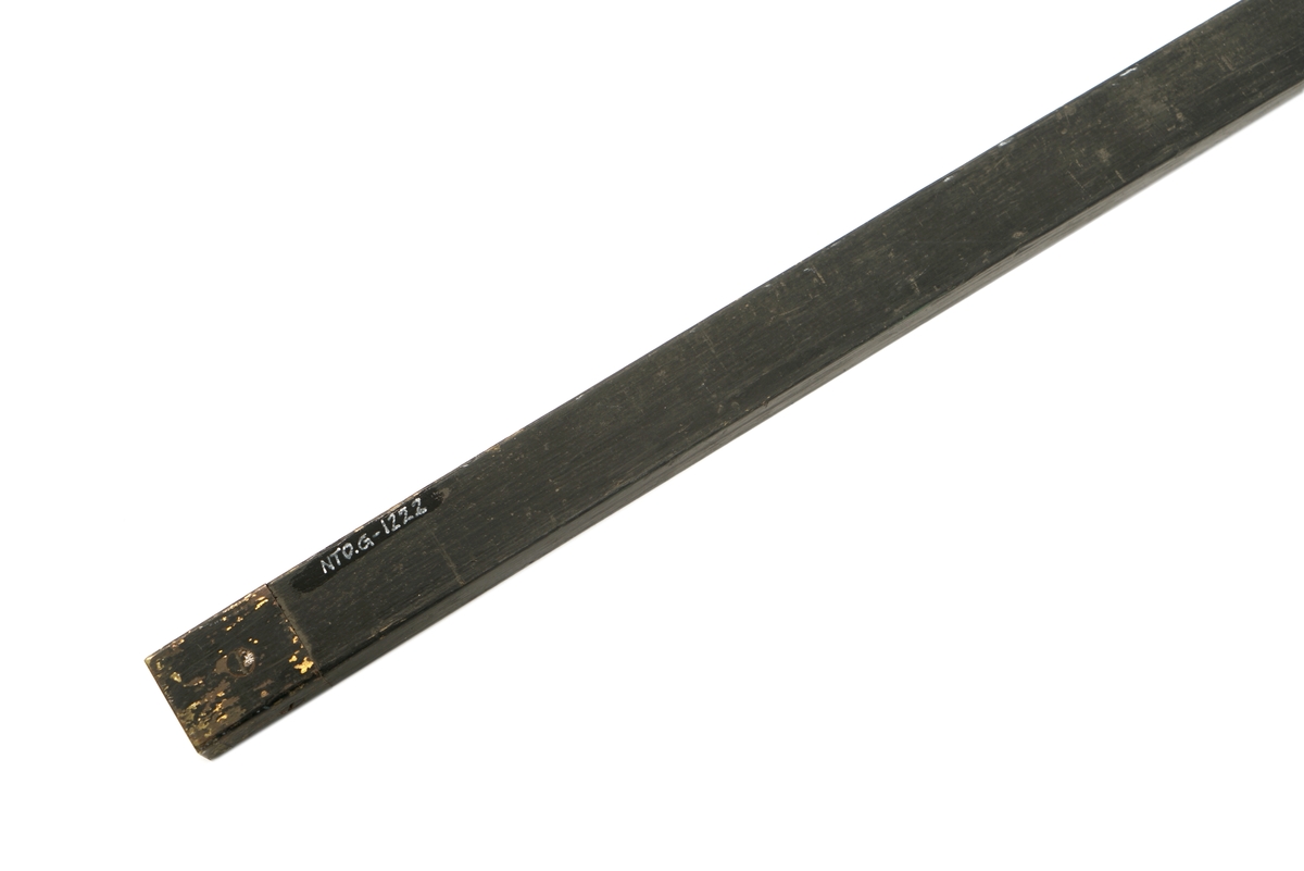 1 firkantet trestang hvor den ene siden er konkav. På den konkave siden er det avtegnet lengdemål i fot. Stangen er beslått med metall i endene.