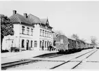 Berga station.Tåg med person- och godsvagnar, tre G-vagnar av olika utförande. Station anlagd 1873. Ursprungliga stationshuset envånings i trä. Stationshuset har blivit nybyggt efter en brand. Nuvarande stationshus två våningar, putsat. Mekanisk växelförregling.