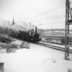 Statens Järnvägar SJ 1856-1956. 100-årsjubileum.Tåg med gamla lok och vagnar vid Tegelbacken.  På bilden syns lok nummer 3 Prins August, senare Statens Järnvägar SJ Bb 43, vid brofästet Norr Mälarstrand på Sträckan mellan Riddarholmen och Stockholm Central.