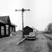 Tvättlina har fästs mellan flaggstång (ej i bild) och semafor för vädring/torkning av mattor. Järnvägsspåren har blivit en bilväg. Stationen lades ned 1959.