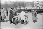 Man med cykel samtalar med järnvägspersonal. I bakgrunden syns gengasutrustade bilar.